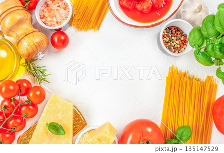 Italian cooking ingredients frame with pasta tomatoes cheese basil and olive oil on white background 135147529