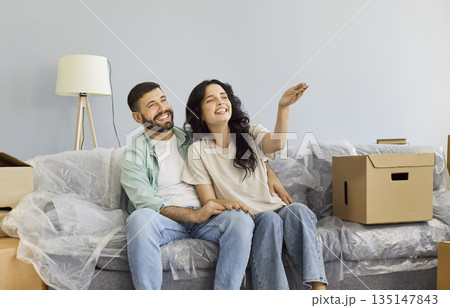 Happy couple planning future decor and design of new home apartment, hugging Happy couple planning future decor and design of new home apartment, hugging 135147843