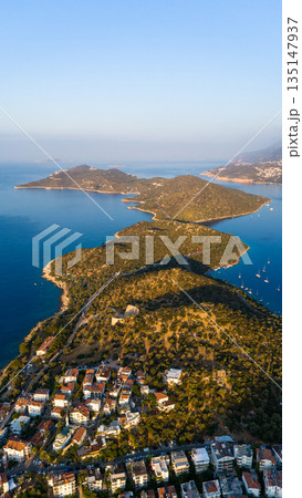Aerial view of Kas peninsula with green hills, coastline and blue Mediterranean sea. Coastal town, islands, yachts and scenic landscape in Kas, Turkey. 135147937