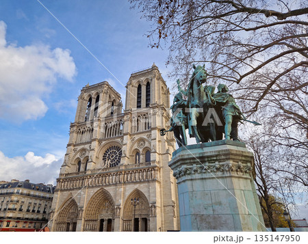 Paris, France - December 10, 2025: Low-angle view of the Notre-Dame Cathedral in Paris and the bronze Charlemagne and his Guards statue stands prominently against the iconic twin towers Paris, France - December 10, 2025: Low-angle view of the Notre-Dame Cathedral in Paris and the bronze Charlemagne and his Guards statue stands prominently against the iconic twin towers 135147950