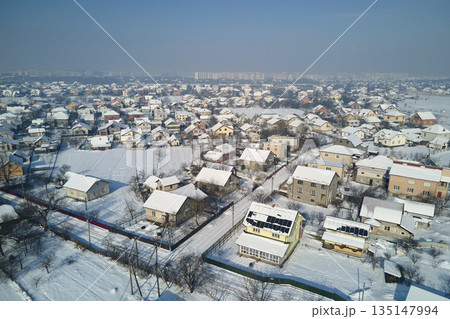 Aerial view of residential houses with snow covered rooftops in suburban rural town area in winter 135147994