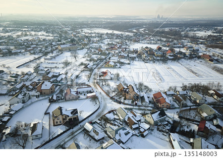 Aerial view of private homes with snow covered roofs in rural suburbs town area in cold winter Aerial view of private homes with snow covered roofs in rural suburbs town area in cold winter 135148003