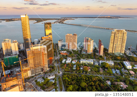 Aerial view of downtown office district of Miami Brickell in Florida, USA at sunset. High commercial and residential skyscraper buildings in modern American megapolis Aerial view of downtown office district of Miami Brickell in Florida, USA at sunset. High commercial and residential skyscraper buildings in modern American megapolis 135148051