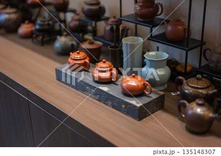 Display Of Ornate Teapots And Cups In A Charming Setting 135148307