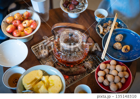 Top View of a Traditional Chinese Tea Gathering with Snacks and Charcoal Teapot Top View of a Traditional Chinese Tea Gathering with Snacks and Charcoal Teapot 135148310