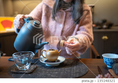 Pouring Flavored Tea From Modern Teapot Into Traditional Cups Pouring Flavored Tea From Modern Teapot Into Traditional Cups 135148321
