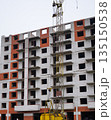 Tall apartment building under construction with crane. 135150538