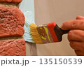 Outdoor wall painting by color brush. Handyman painting concrete block wall. 135150539