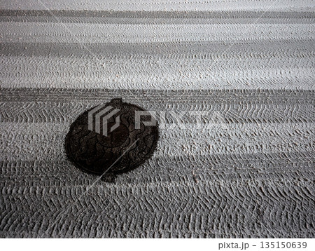 Tire marks on freshly fallen snow on a road at night 135150639