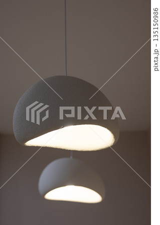 Two modern pendant lamps illuminating a room Two modern pendant lamps illuminating a room 135150986