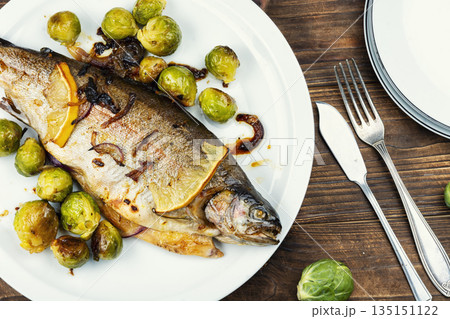 Baked trout with brussels sprouts on wooden surface. Baked trout with brussels sprouts on wooden surface. 135151122