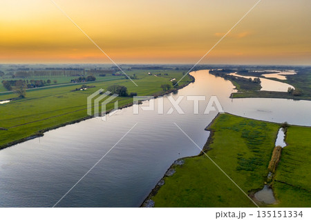 Lowland river IJssel through sunset landscape Lowland river IJssel through sunset landscape 135151334