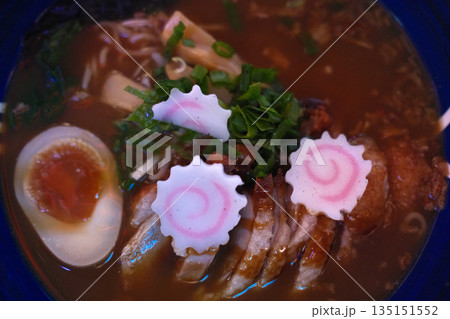 A delicious bowl of traditional Japanese ramen with pork, egg, noodles, and flavorful broth. 135151552