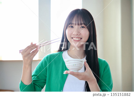 ご飯を食べる若い女性 135151882