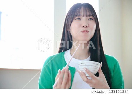 ご飯を食べる若い女性 135151884