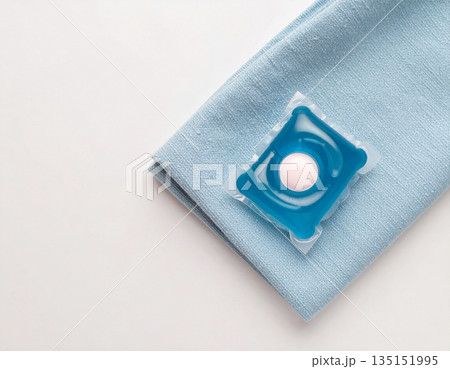 Home cleaning. Soluble laundry detergent capsule on a neutral linen cloth with empty space for text. Home cleaning. Soluble laundry detergent capsule on a neutral linen cloth with empty space for text. 135151995