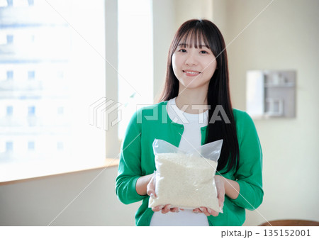 お米を持つ若い女性 135152001