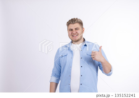 Happy man in a light blue shirt showing a thumbs up. Happy man in a light blue shirt showing a thumbs up. 135152241