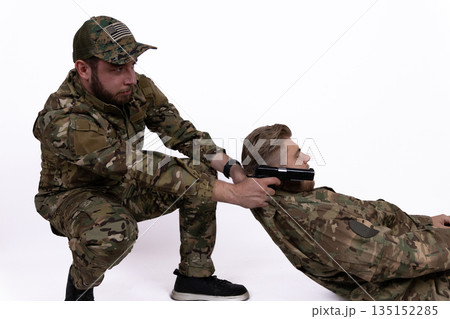 Soldier in camouflage uniform performing a tactical arrest. Soldier in camouflage uniform performing a tactical arrest. 135152285