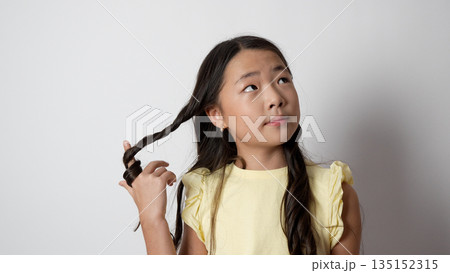 Girl touching her hair and looking at the camera. Girl touching her hair and looking at the camera. 135152315