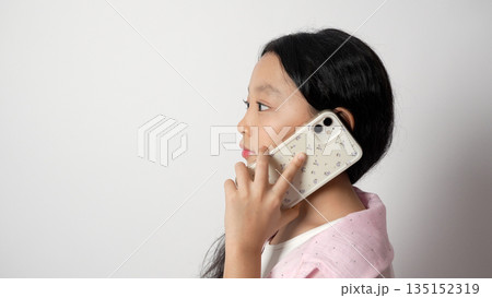 Girl talking on a smartphone and looking away. Girl talking on a smartphone and looking away. 135152319