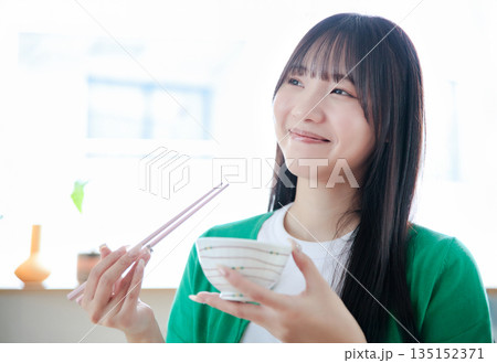 ご飯を食べる若い女性 135152371