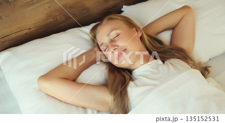 Woman sleeping lying in bed on white soft comfortable pillow in bedroom at home 135152531