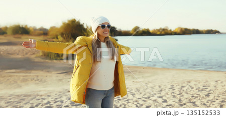 Happy smiling woman on beach, enjoying amazing landscape, warm weather standing on sea coast Happy smiling woman on beach, enjoying amazing landscape, warm weather standing on sea coast 135152533