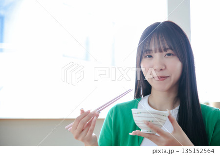 ご飯を食べる若い女性 135152564