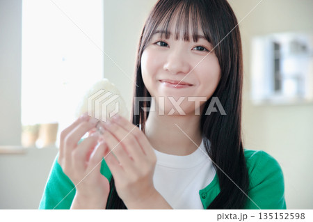 おにぎりを美味しそうに食べる若い女性 135152598