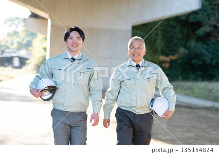 歩くベテランと若手技術者 135154824