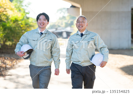 歩くベテランと若手技術者 135154825