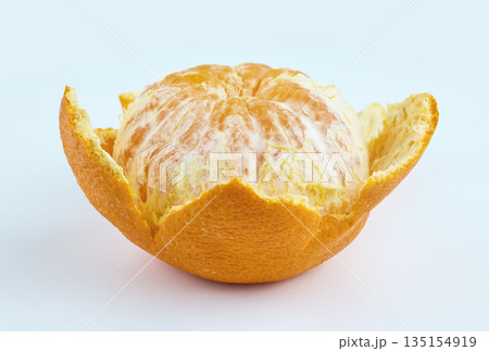A fresh whole mandarin orange partially peeled, showing juicy segments against a clean white backdrop 135154919