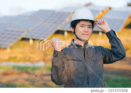 ソーラーパネルの前に立つ作業員 135155508