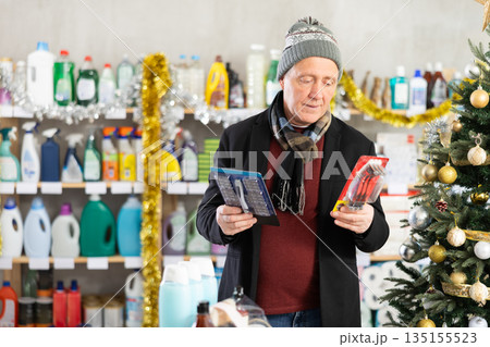 Senior man select and studies label razor on New Year Eve 135155523