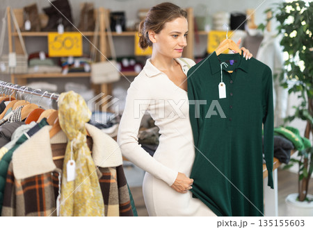Woman choosing a warm dress in a store Woman choosing a warm dress in a store 135155603