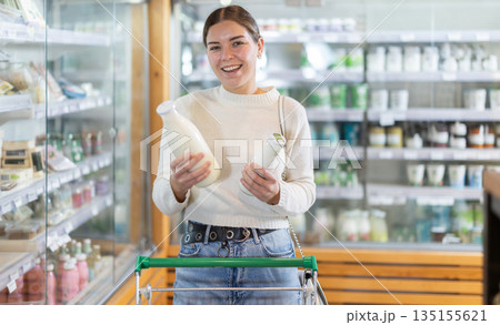 Young woman choosing milk in grocery supermarket Young woman choosing milk in grocery supermarket 135155621