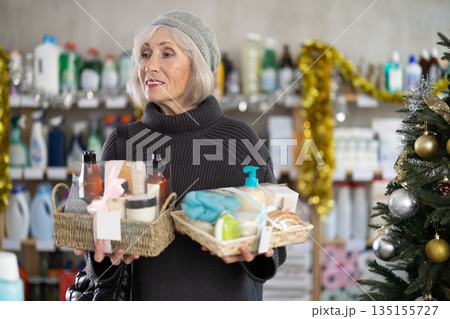 Mature woman shopping for Christmas presents at home goods store Mature woman shopping for Christmas presents at home goods store 135155727