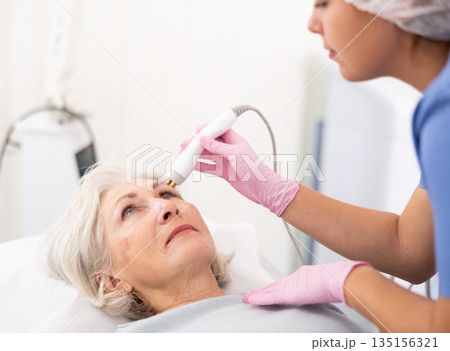 Old woman having face radiolifting procedure 135156321