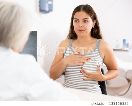 Young woman patient viewing silicone for mammoplasty in aesthetic clinic 135156322