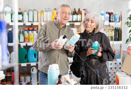 Husband and wife choose shampoo or shower gel together in supermarket Husband and wife choose shampoo or shower gel together in supermarket 135156332