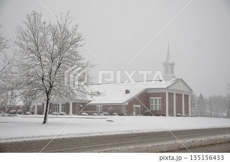 Classic Church Building with Green Lawn and Steeple in winter time  135156433