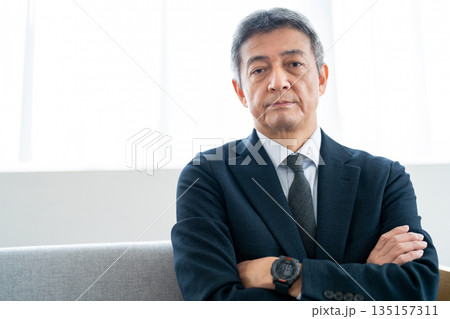 腕を組み自信を感じさせるシニアビジネスマン 135157311