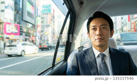 都会の街をタクシー移動する40代日本人男性 135157540