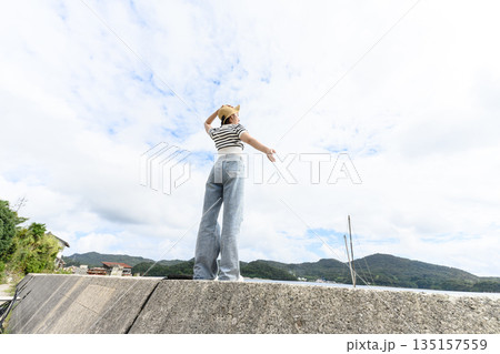 堤防で海を見る女性 【撮影協力：隠岐シーサイドリゾートみやび様】 135157559