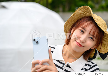 麦わら帽子で自撮りする女性 【撮影協力：隠岐シーサイドリゾートみやび様】 135157570