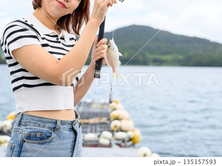 釣り上げた魚と笑顔の女性 【撮影協力：隠岐シーサイドリゾートみやび様】 135157593