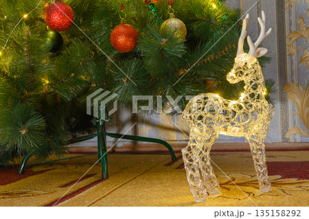 christmas reindeer with lights against the background of pine branches 135158292