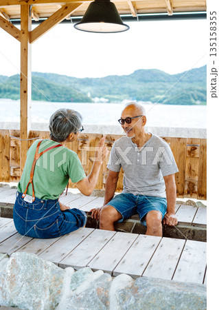 高齢夫婦が足湯で会話 【撮影協力:隠岐シーサイドリゾートみやび様】 高齢夫婦が足湯で会話 【撮影協力:隠岐シーサイドリゾートみやび様】 135158355