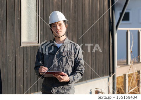木造住宅の前に立つ現場監督 135158434